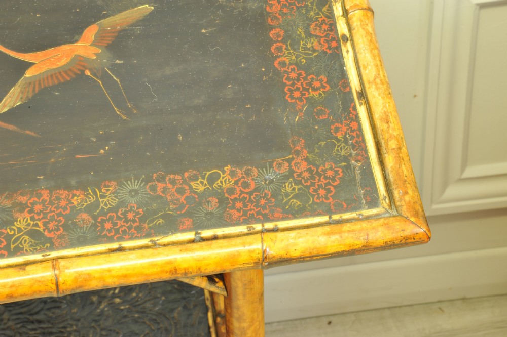 A late Victorian two-tier bamboo side table featuring a dark lacquered top panel decorated with botanical flora and birds. View XII