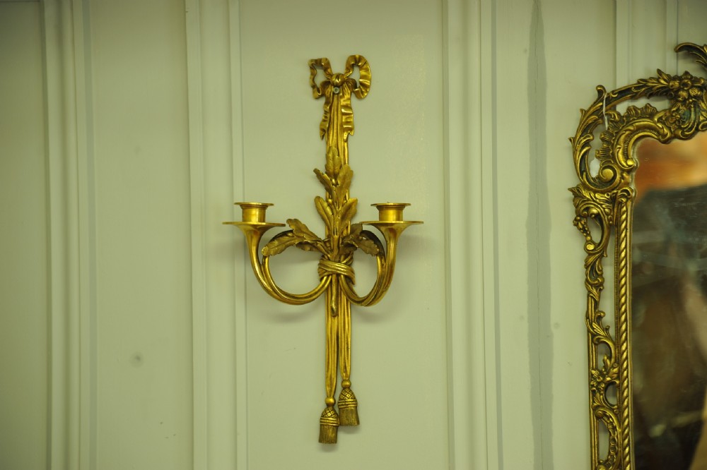 A pair of nineteenth-century French gilt bronze wall sconces featuring ribbon bow tops, tassel drops, and two curved candle branches. View II
