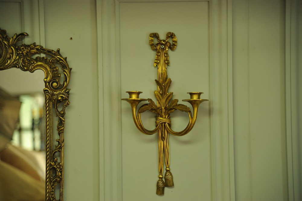 A pair of nineteenth-century French gilt bronze wall sconces featuring ribbon bow tops, tassel drops, and two curved candle branches. View III