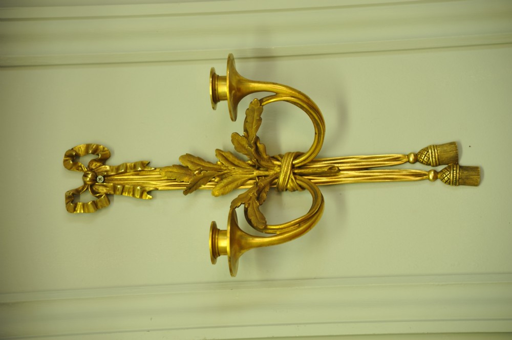 A pair of nineteenth-century French gilt bronze wall sconces featuring ribbon bow tops, tassel drops, and two curved candle branches. View IV
