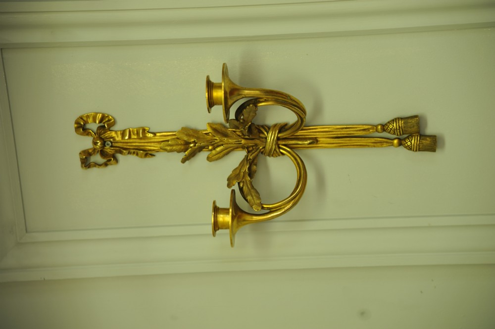 A pair of nineteenth-century French gilt bronze wall sconces featuring ribbon bow tops, tassel drops, and two curved candle branches. View V