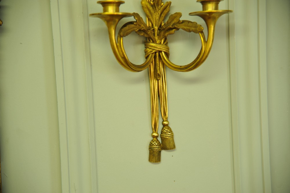 A pair of nineteenth-century French gilt bronze wall sconces featuring ribbon bow tops, tassel drops, and two curved candle branches. View VI