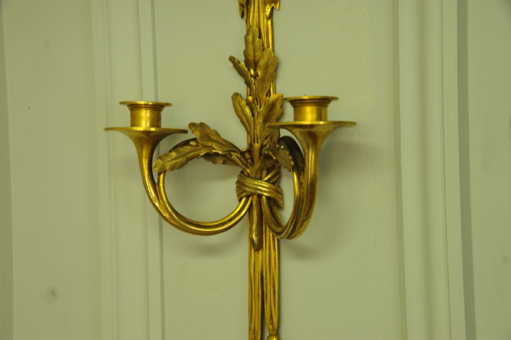 A pair of nineteenth-century French gilt bronze wall sconces featuring ribbon bow tops, tassel drops, and two curved candle branches. View VIII