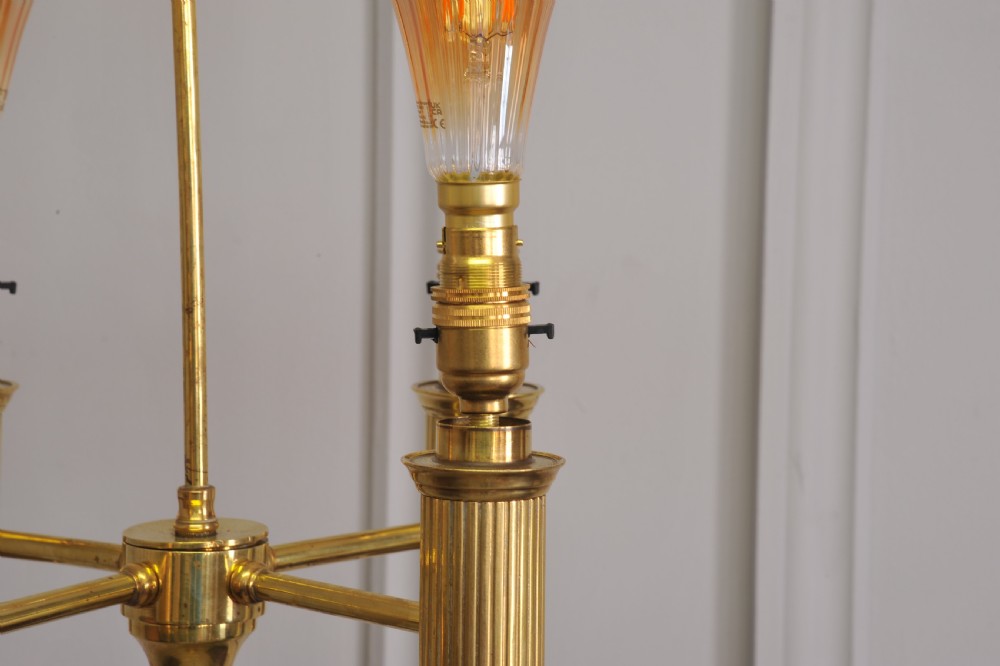 A brass French bouillotte style standard lamp featuring four fluted candle sockets with tulip glass shades and a central ring finial. View X