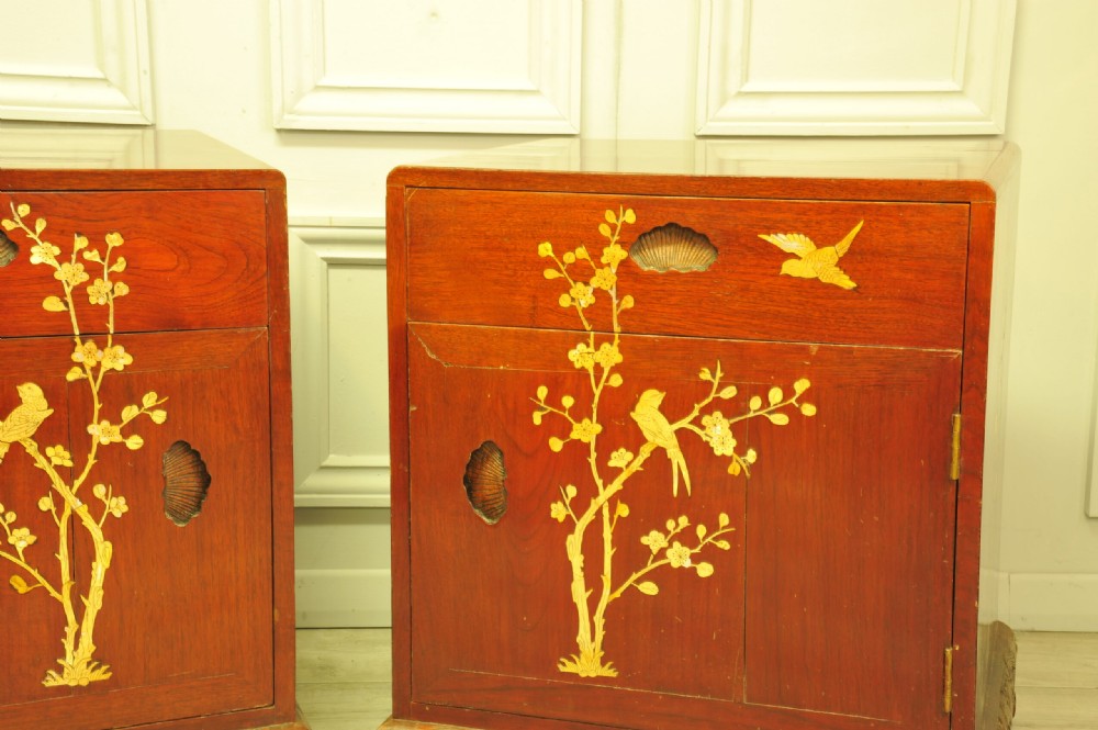 A pair of reddish-brown wood side cabinets featuring hand-painted gilt Chinoiserie floral and bird motifs resting on carved plinths. View VI