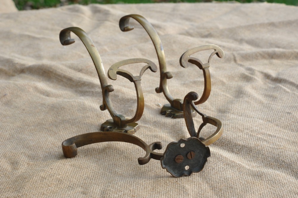 A set of three antique French cast bronze wall-mounted hat and coat hooks with scrolled upper arms and shaped lower pegs. View II