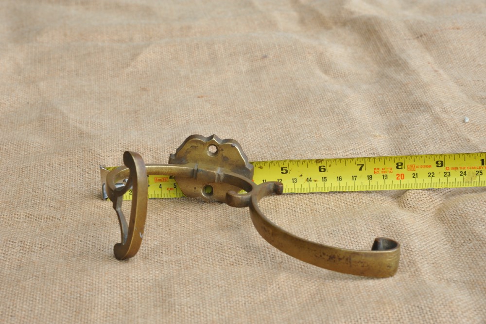 A set of three antique French cast bronze wall-mounted hat and coat hooks with scrolled upper arms and shaped lower pegs. View VII
