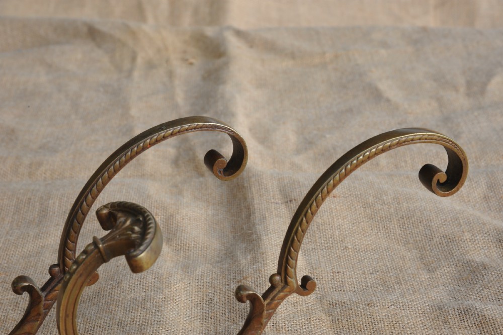 A pair of ornate antique French cast bronze dual-prong wall hooks featuring scrolling upper arms and decorative detailed bases. View III