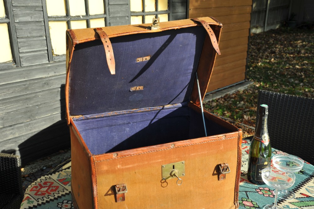 A square antique tan canvas travel case featuring stitched brown leather edging, a top carrying handle, brass rivets, and an authentic Paddington railway paper label. View XI