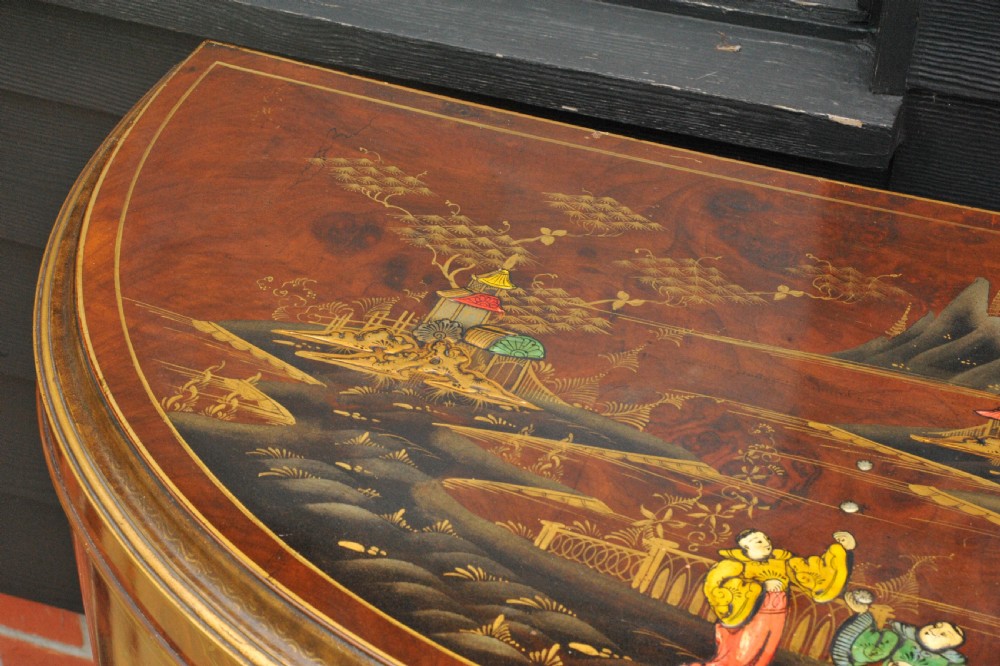 A circa 1910 semi-circular demi-lune cabinet featuring hand-painted Chinoiserie figures and landscapes with gilt details on cabriole legs. View VI