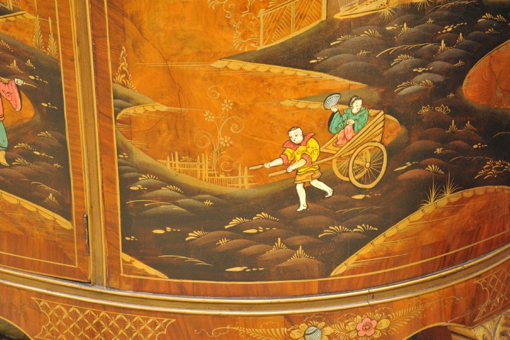 A circa 1910 semi-circular demi-lune cabinet featuring hand-painted Chinoiserie figures and landscapes with gilt details on cabriole legs. View XXX