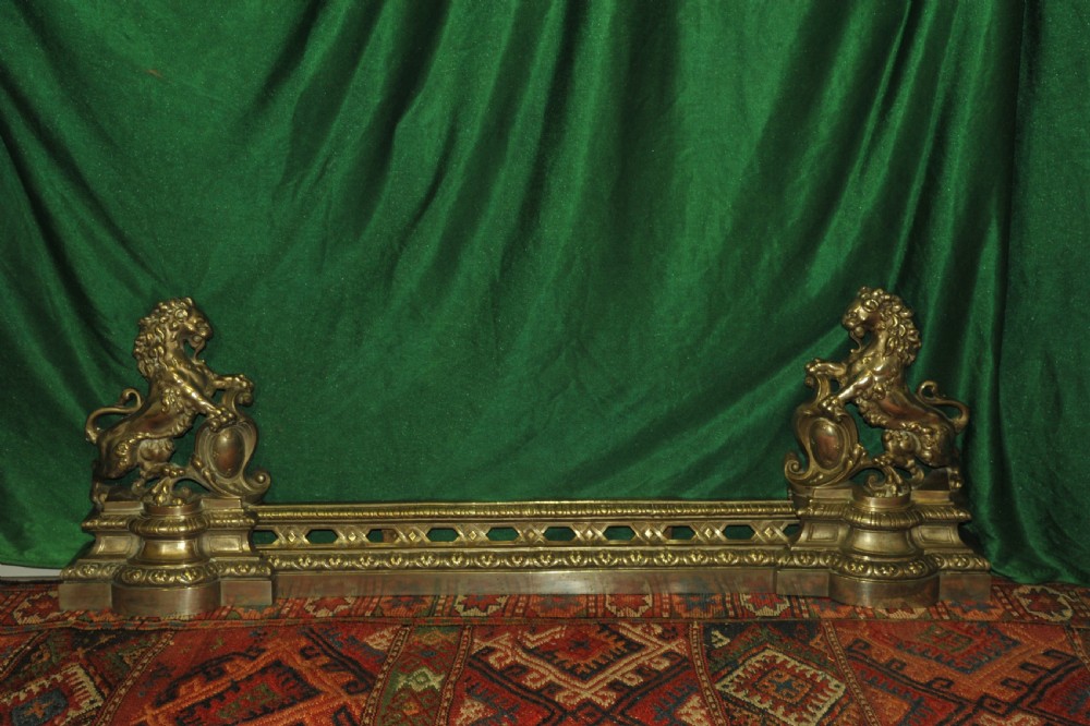 A cast brass Louis XV style fireplace fender featuring a central pierced lattice gallery flanked by two sculpted lions resting on shields. View VI