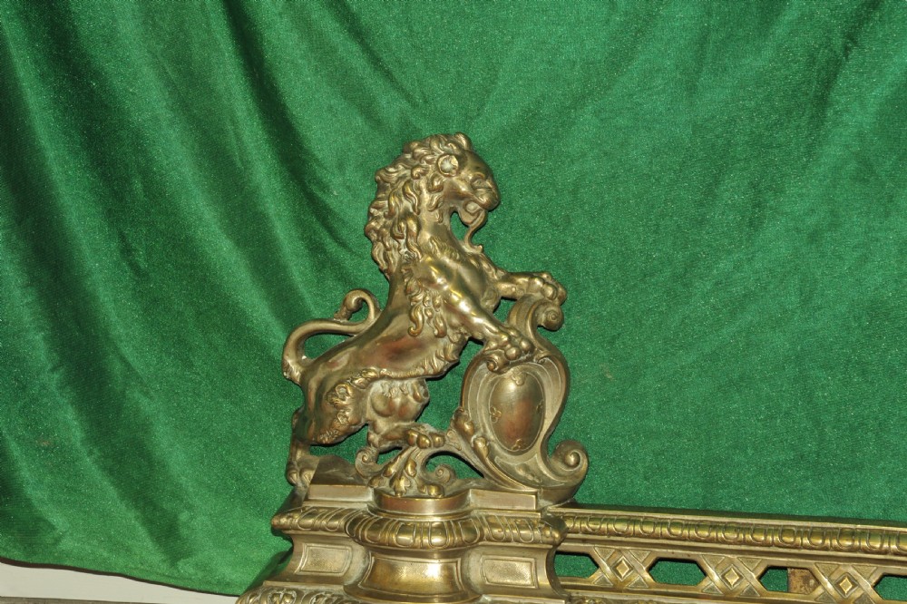 A cast brass Louis XV style fireplace fender featuring a central pierced lattice gallery flanked by two sculpted lions resting on shields. View VII