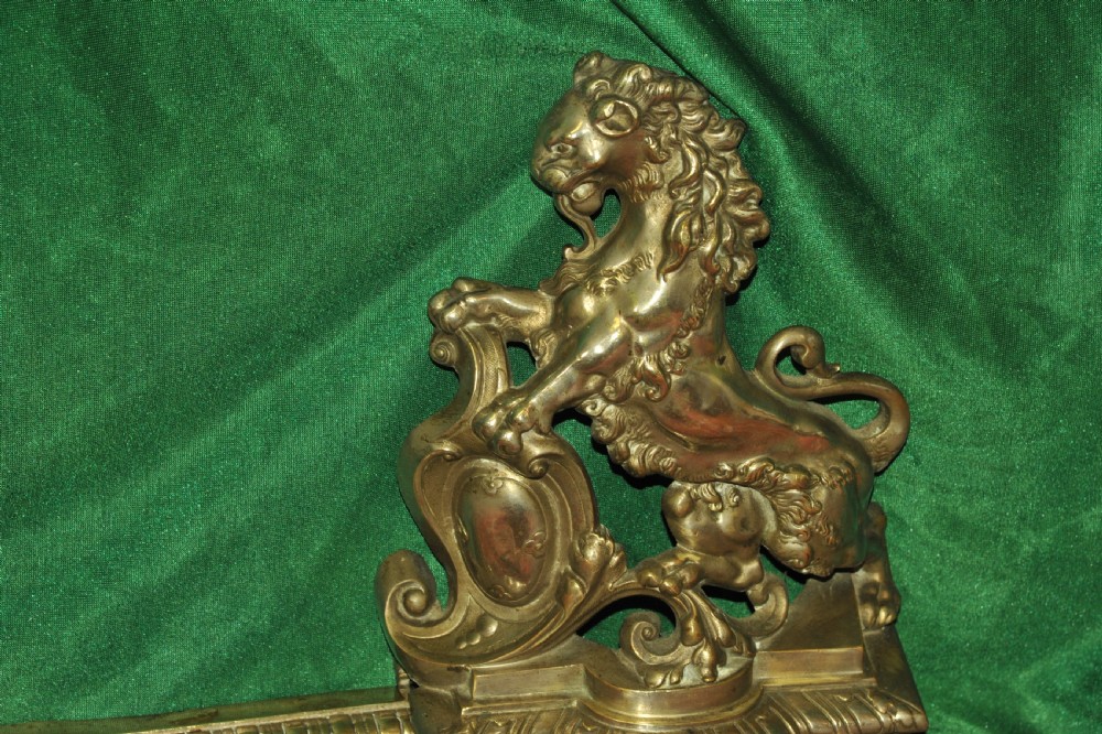 A cast brass Louis XV style fireplace fender featuring a central pierced lattice gallery flanked by two sculpted lions resting on shields. View X
