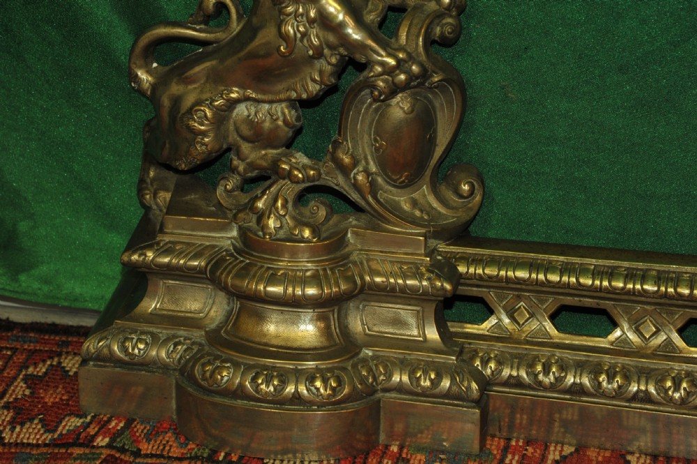 A cast brass Louis XV style fireplace fender featuring a central pierced lattice gallery flanked by two sculpted lions resting on shields. View XII