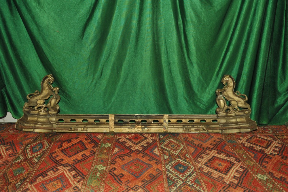 A cast brass Louis XV style fireplace fender featuring a central pierced lattice gallery flanked by two sculpted lions resting on shields. View XIV