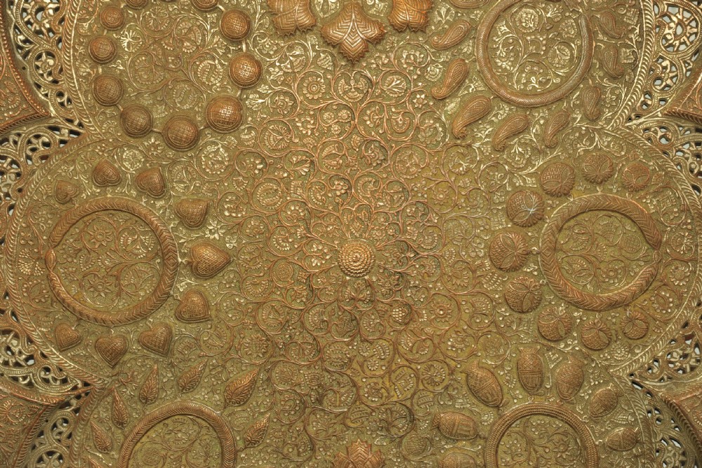 An antique Kashmiri lobed copper tray featuring detailed repousse floral work, pierced openwork sections, and residual silver plating. View V