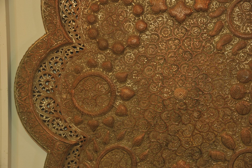 An antique Kashmiri lobed copper tray featuring detailed repousse floral work, pierced openwork sections, and residual silver plating. View VII