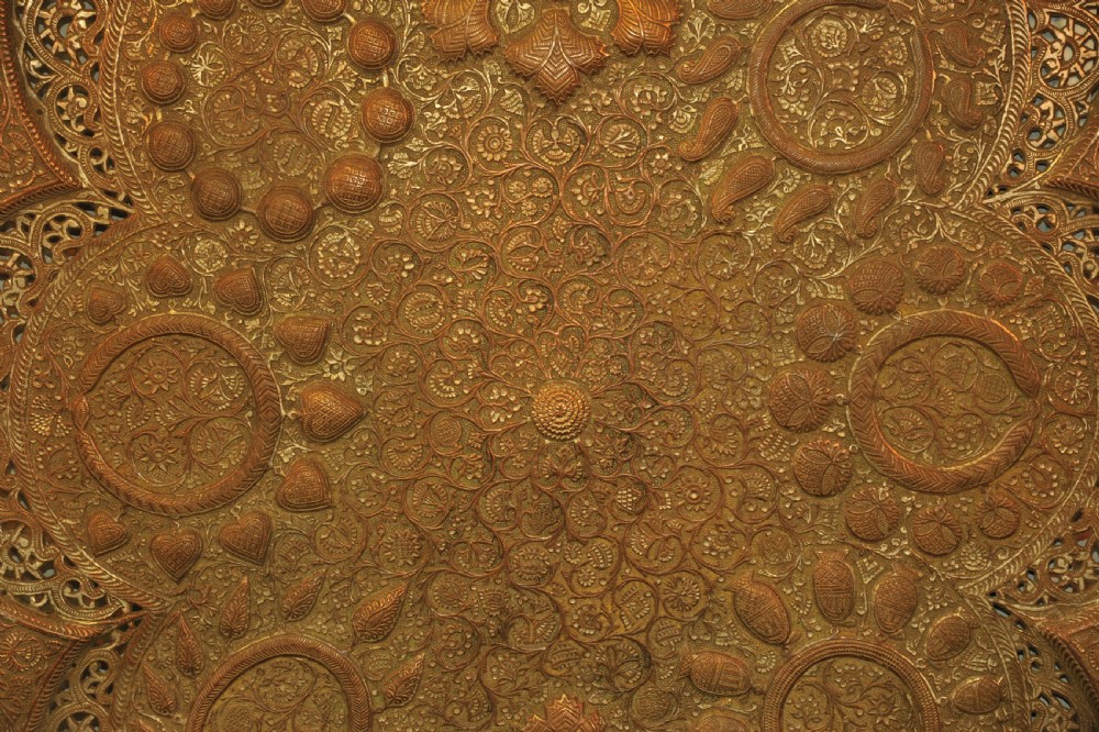 An antique Kashmiri lobed copper tray featuring detailed repousse floral work, pierced openwork sections, and residual silver plating. View IX