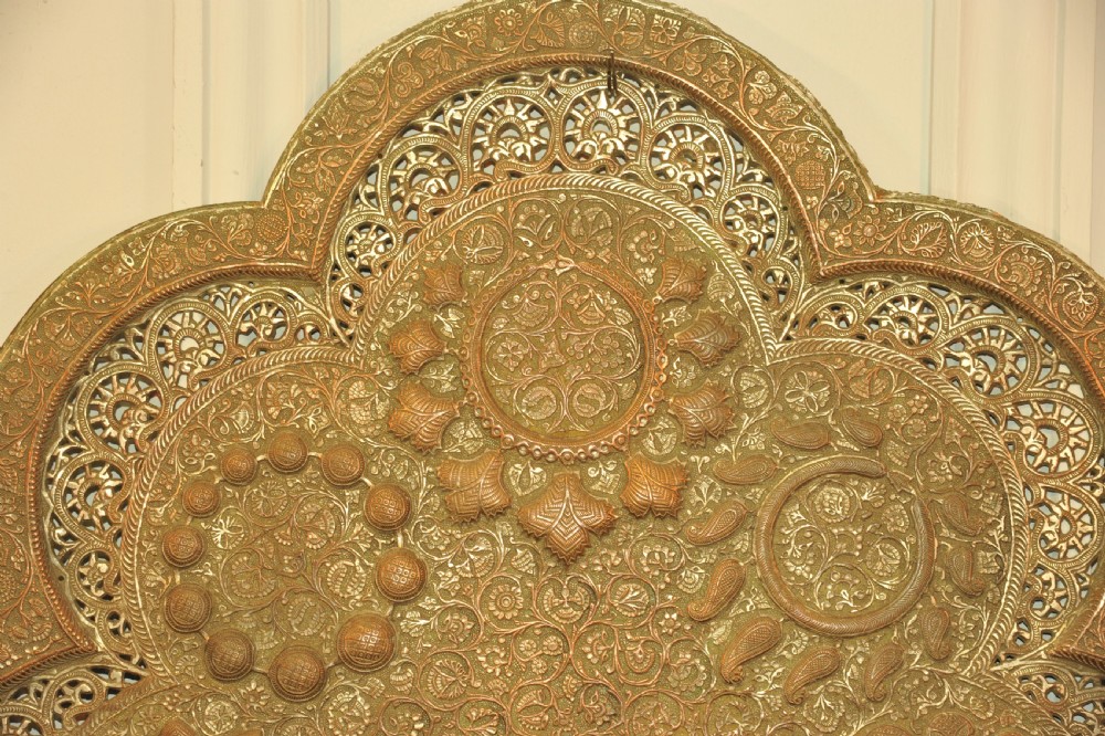 An antique Kashmiri lobed copper tray featuring detailed repousse floral work, pierced openwork sections, and residual silver plating. View X