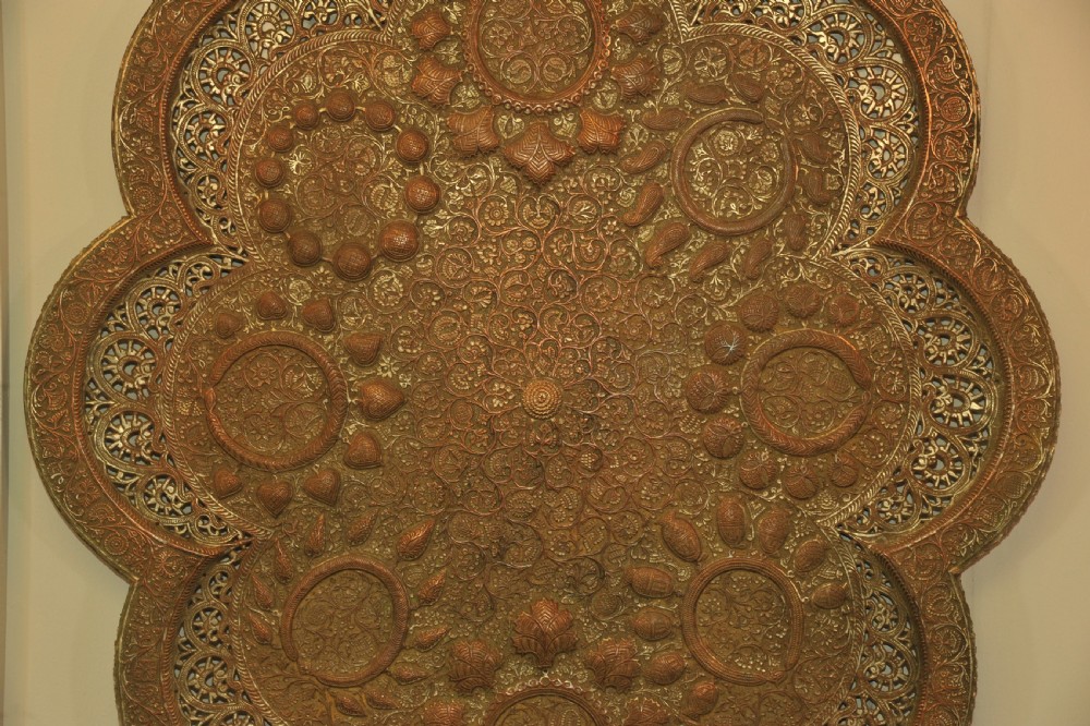 An antique Kashmiri lobed copper tray featuring detailed repousse floral work, pierced openwork sections, and residual silver plating. View XV