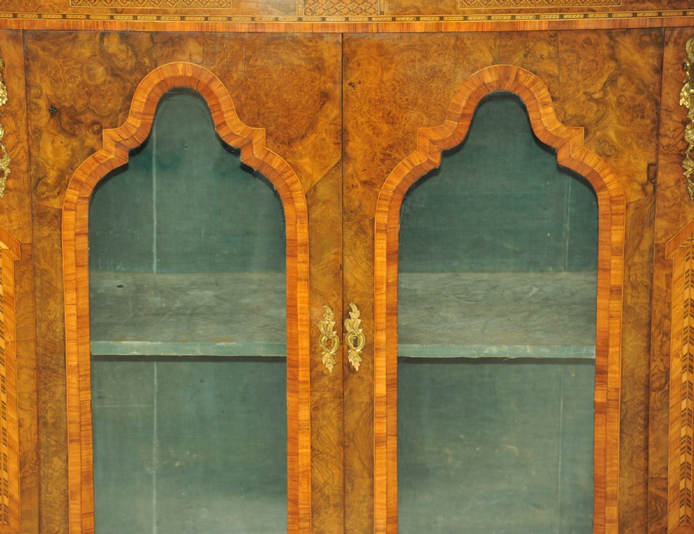 A Victorian burr walnut breakfront cabinet featuring four arched glazed doors, Tunbridgeware mosaic borders, and gilt bronze mounts. View II