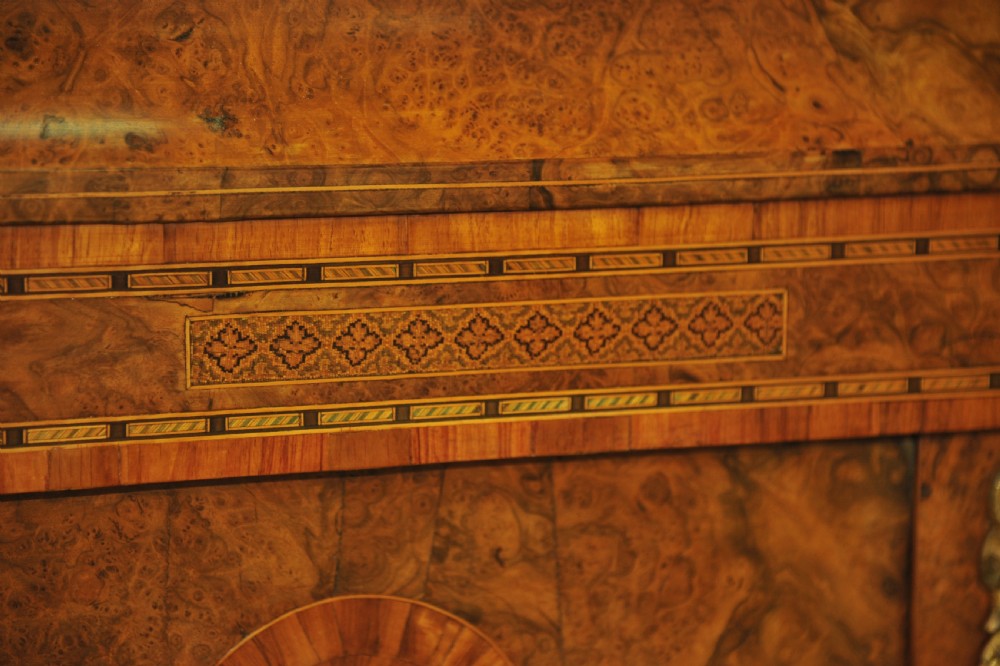 A Victorian burr walnut breakfront cabinet featuring four arched glazed doors, Tunbridgeware mosaic borders, and gilt bronze mounts. View VI