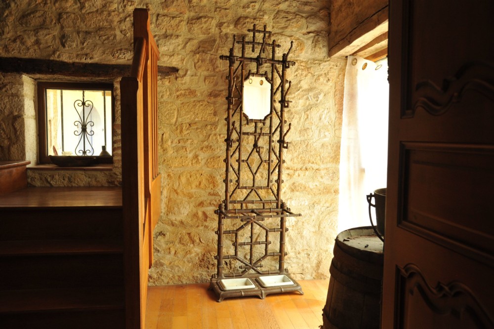 A late 19th-century French cast iron hall stand featuring a faux bamboo frame, central mirror, multiple hanging hooks, and an integrated umbrella rack with base drip trays.