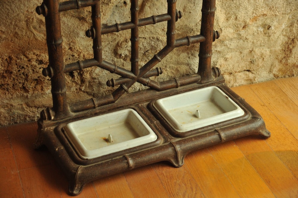 A late nineteenth-century French cast iron hall stand featuring a faux bamboo frame, central mirror, coat hooks, umbrella rail, and dual drip trays. View XI