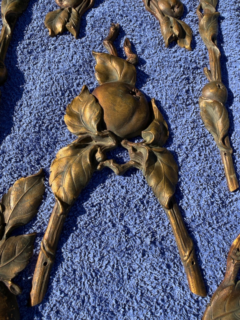 A close-up view of nineteenth-century gilt bronze appliques sculpted with apples, leaves, and branches in high relief. View V