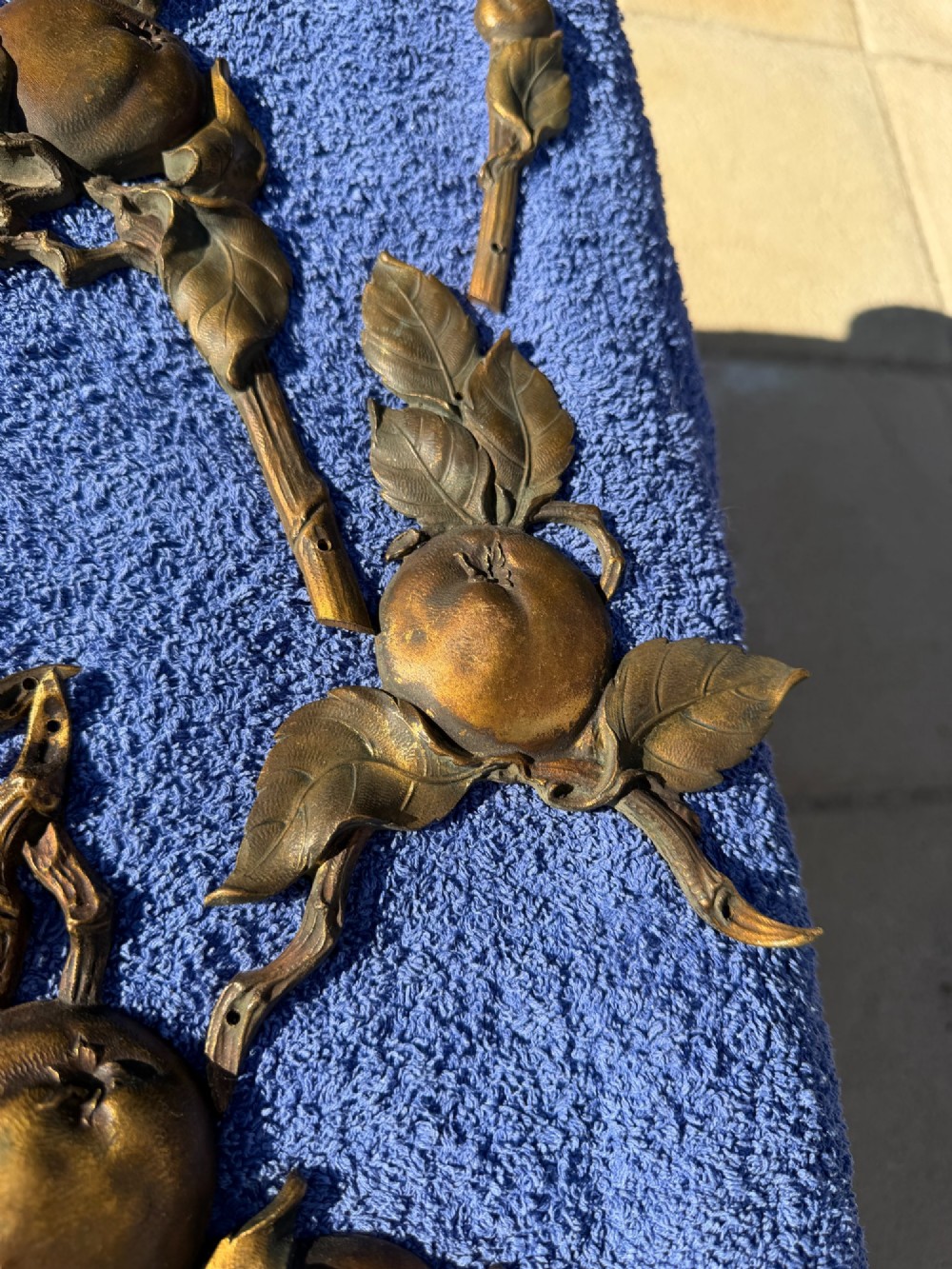 A close-up view of nineteenth-century gilt bronze appliques sculpted with apples, leaves, and branches in high relief. View VI