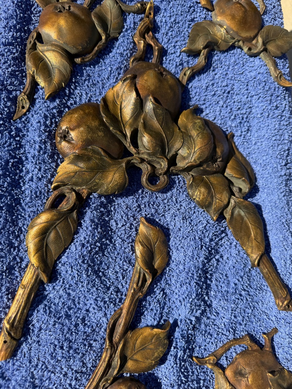 A close-up view of nineteenth-century gilt bronze appliques sculpted with apples, leaves, and branches in high relief. View IX
