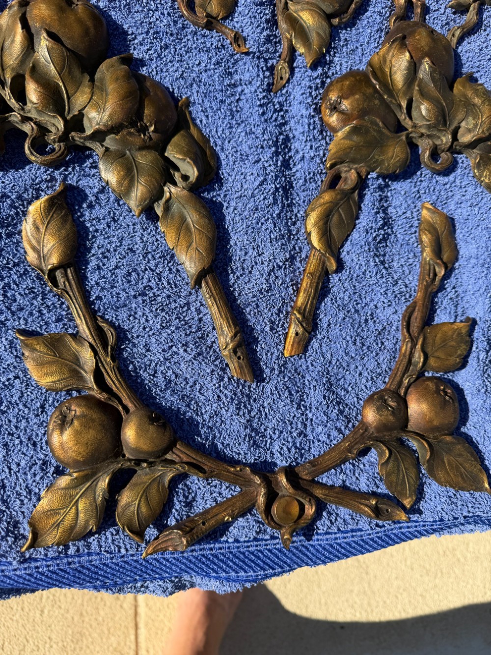 A close-up view of nineteenth-century gilt bronze appliques sculpted with apples, leaves, and branches in high relief. View X