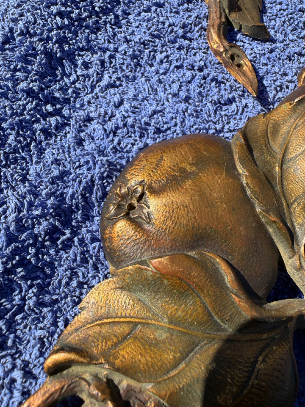 A close-up view of nineteenth-century gilt bronze appliques sculpted with apples, leaves, and branches in high relief. View XII