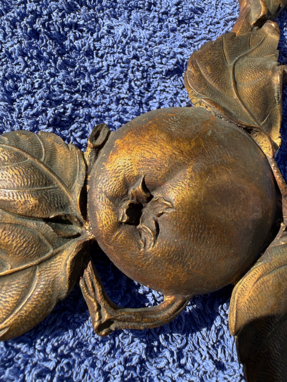 A close-up view of nineteenth-century gilt bronze appliques sculpted with apples, leaves, and branches in high relief. View XIII