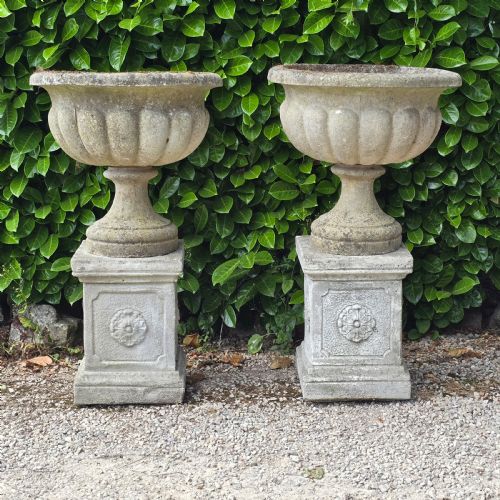 PAIR WELL WEATHERED GARDEN URNS ON PLINTHS