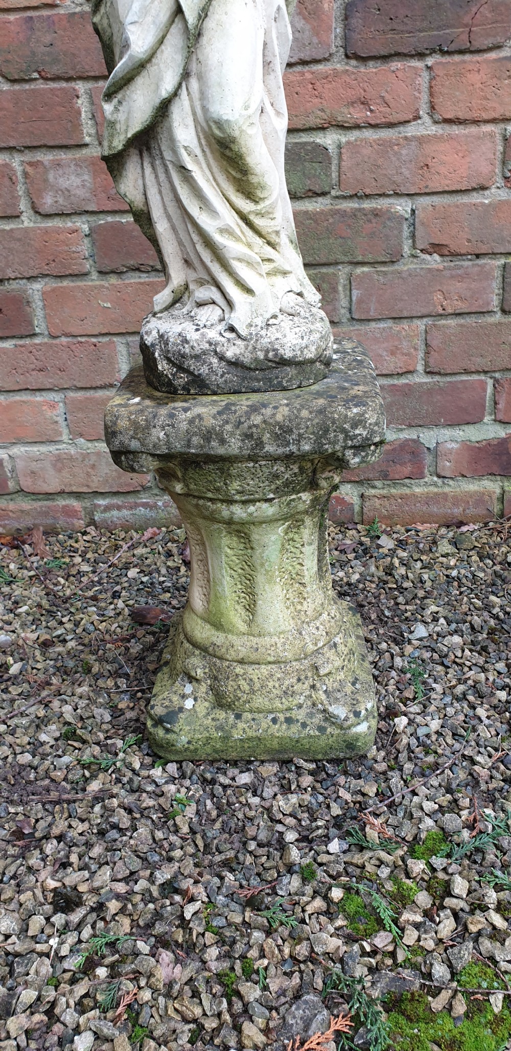 A pair of weathered grey stone statues depicting the Madonna and Child, each mounted on a square tapered plinth base. View II