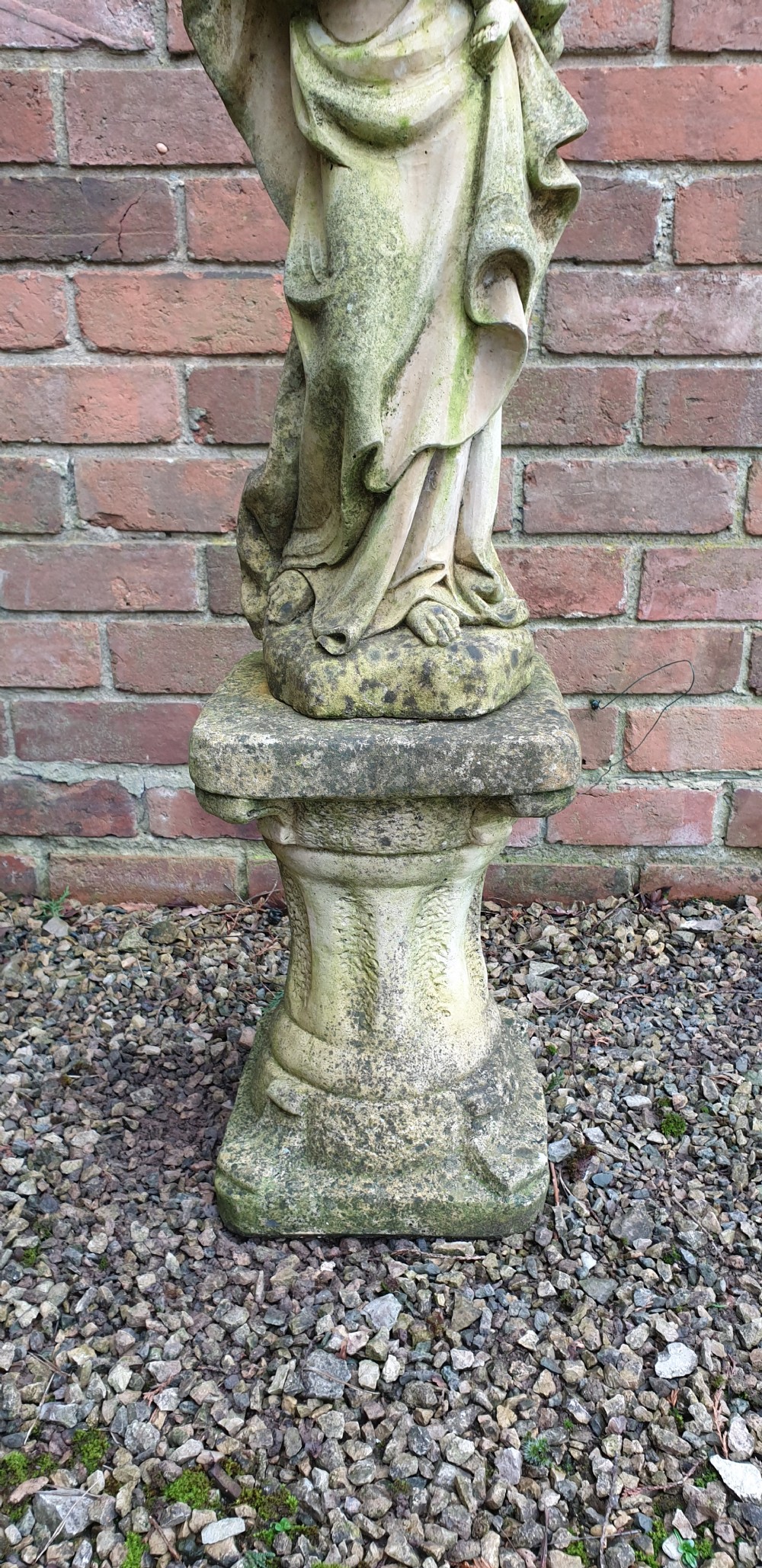 A pair of weathered grey stone statues depicting the Madonna and Child, each mounted on a square tapered plinth base. View IV