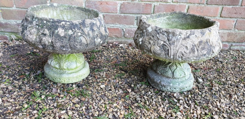 A matching pair of heavy round stone garden planters with carved leaf motifs and natural moss weathering. View II
