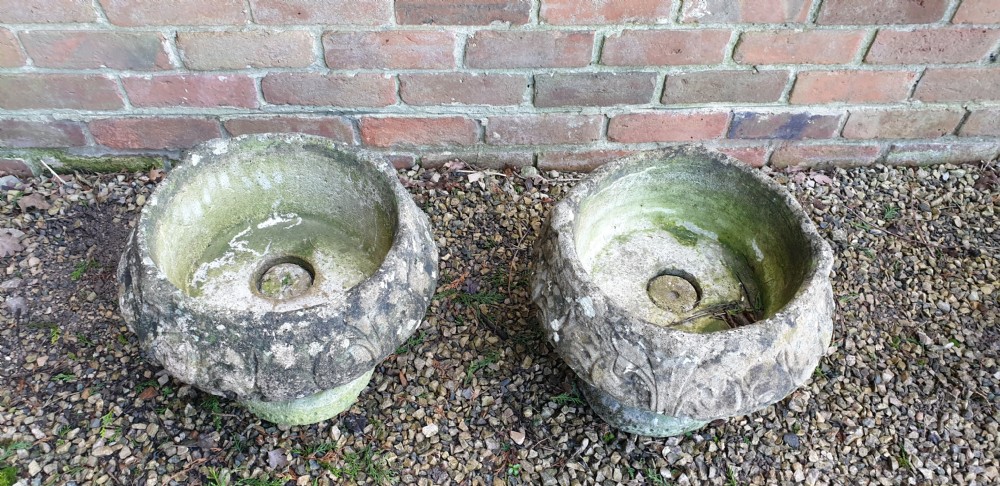 A matching pair of heavy round stone garden planters with carved leaf motifs and natural moss weathering. View III