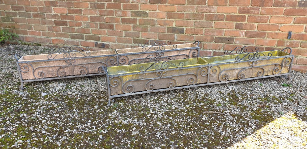 A pair of long rectangular wrought iron garden troughs featuring open scrollwork frames and inner metal insert boxes. View II
