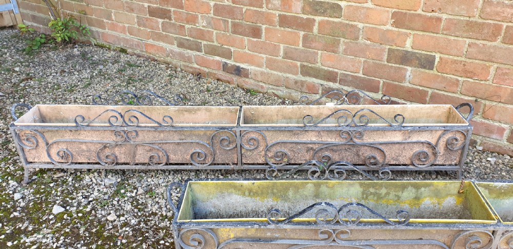 A pair of long rectangular wrought iron garden troughs featuring open scrollwork frames and inner metal insert boxes. View III