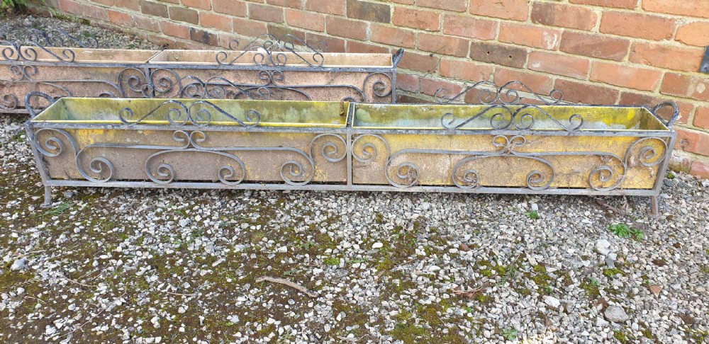 A pair of long rectangular wrought iron garden troughs featuring open scrollwork frames and inner metal insert boxes. View IV