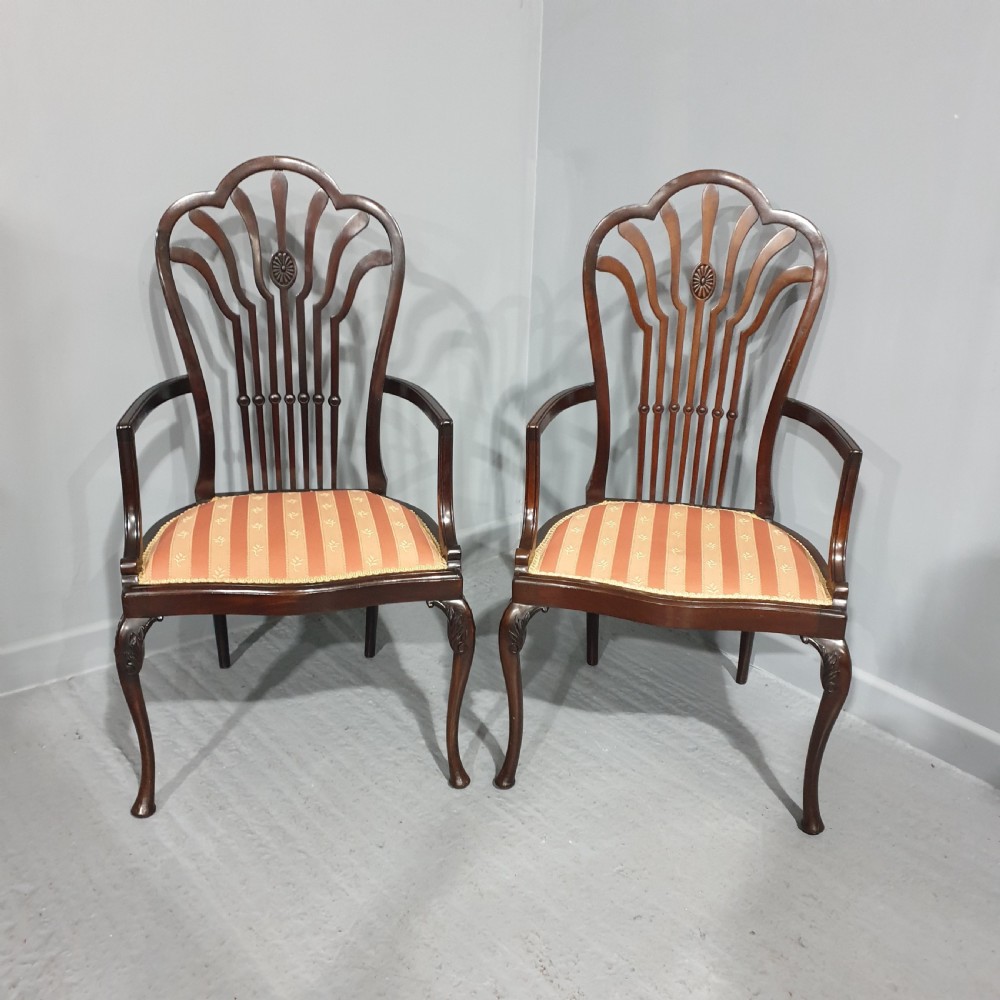 A pair of carved mahogany elbow chairs featuring openwork fan backs, swept armrests, terracotta striped upholstered seats, and cabriole front legs. View II