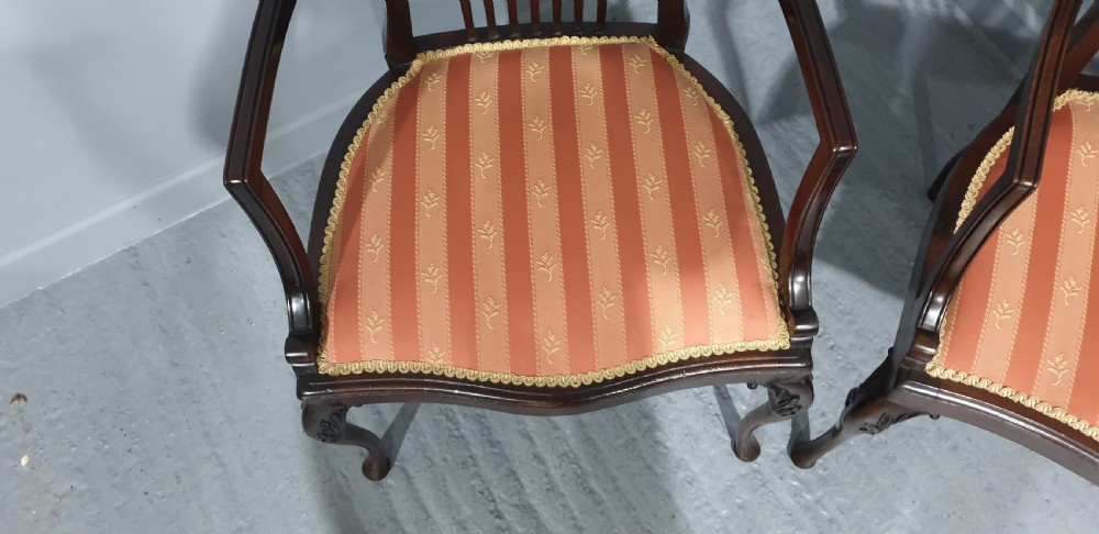 A pair of carved mahogany elbow chairs featuring openwork fan backs, swept armrests, terracotta striped upholstered seats, and cabriole front legs. View III