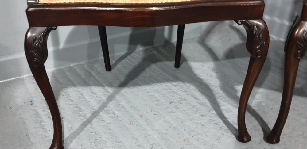 A pair of carved mahogany elbow chairs featuring openwork fan backs, swept armrests, terracotta striped upholstered seats, and cabriole front legs. View VII