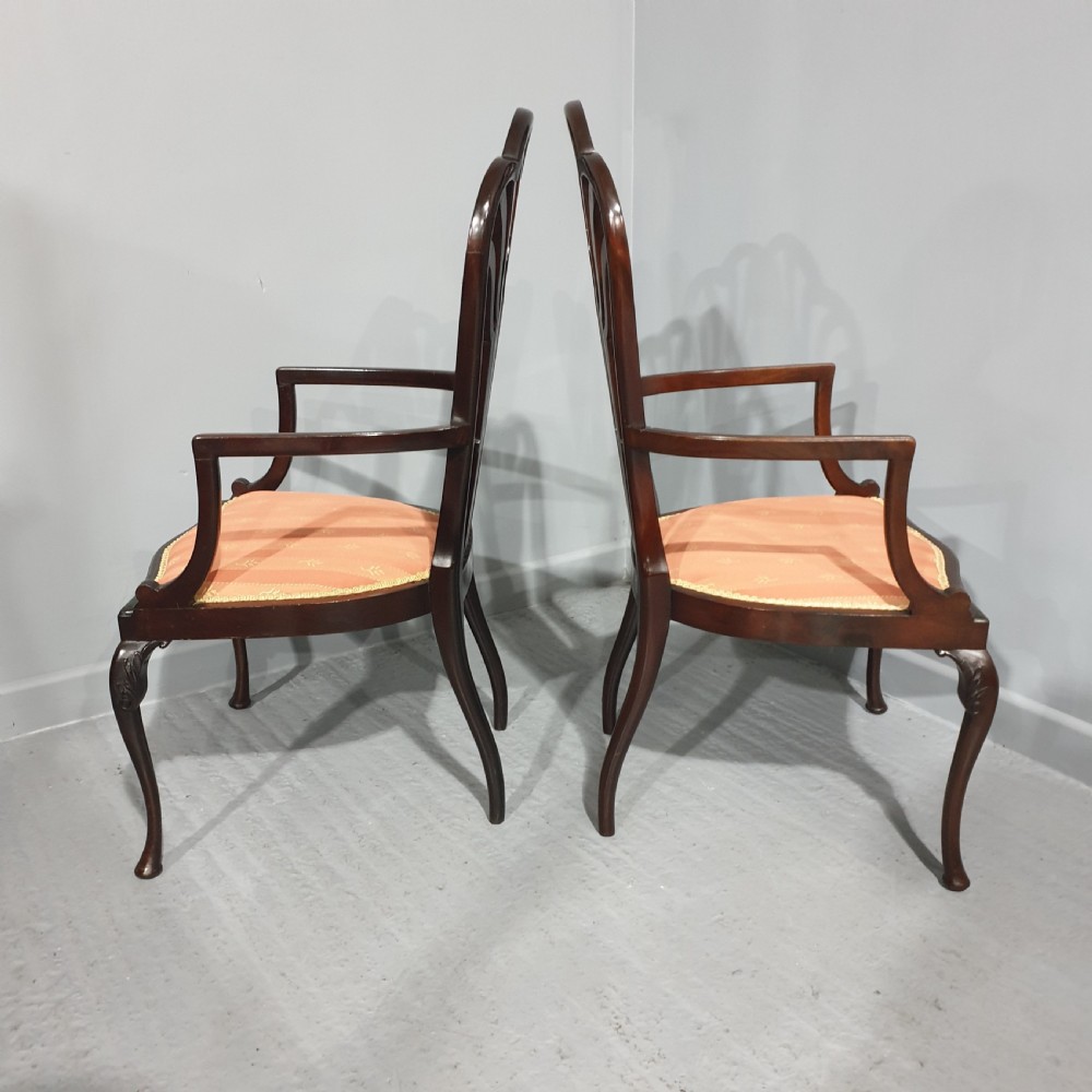 A pair of carved mahogany elbow chairs featuring openwork fan backs, swept armrests, terracotta striped upholstered seats, and cabriole front legs. View VIII