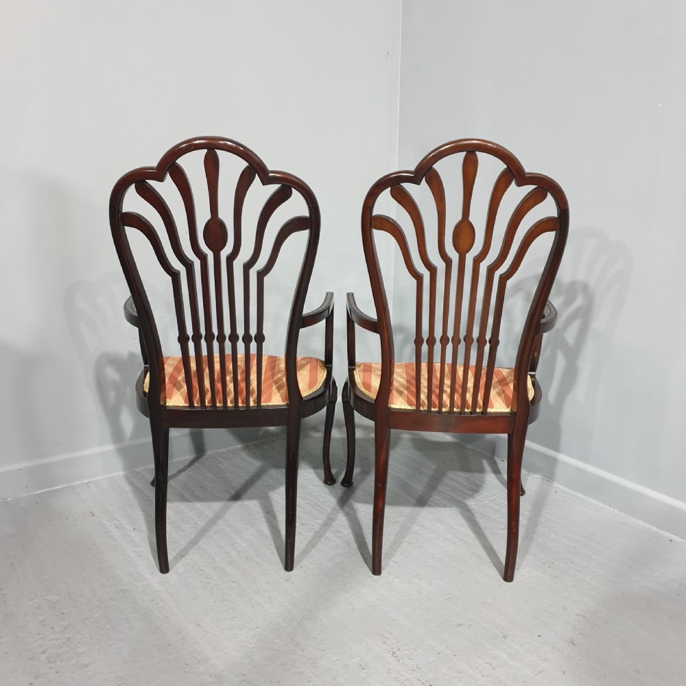 A pair of carved mahogany elbow chairs featuring openwork fan backs, swept armrests, terracotta striped upholstered seats, and cabriole front legs. View IX