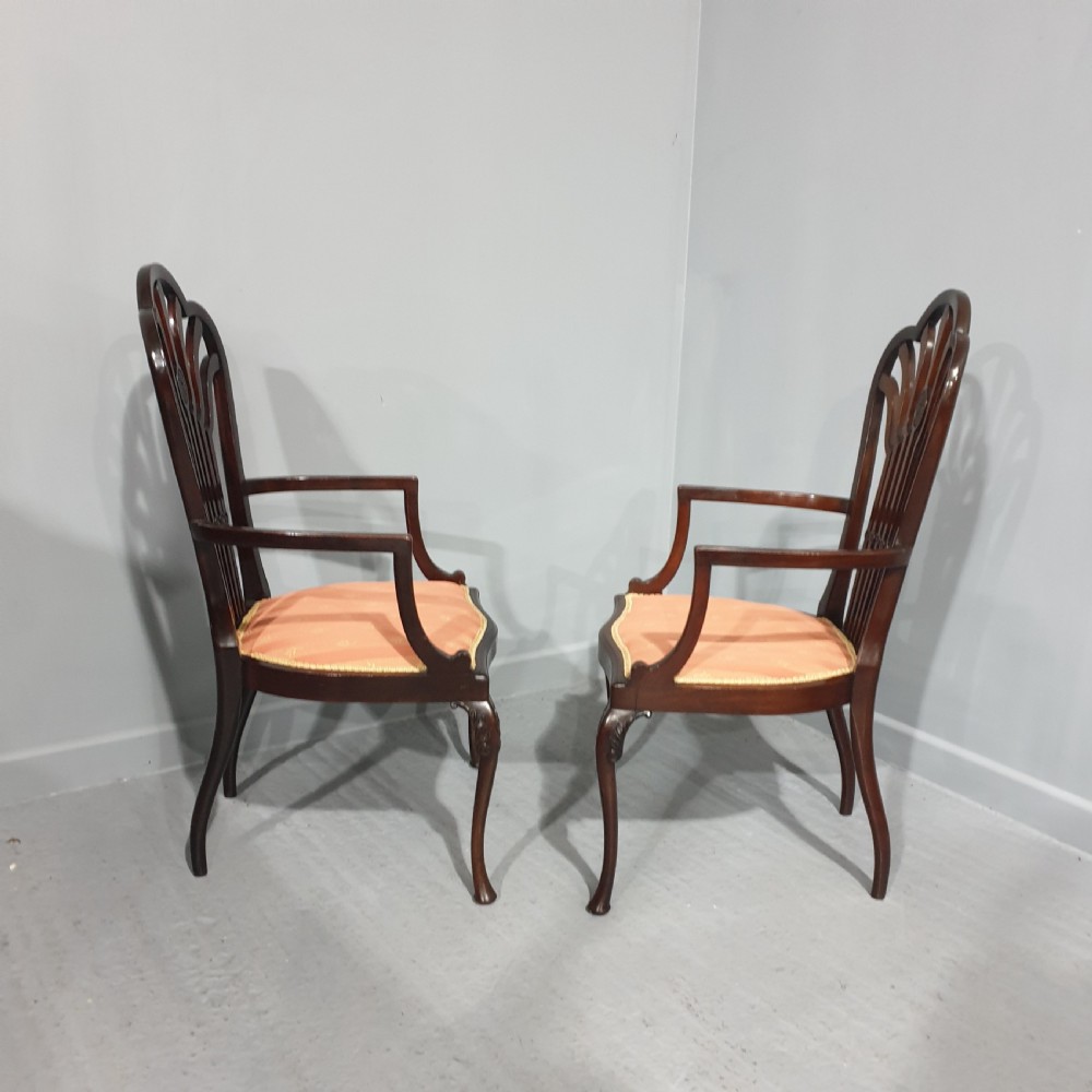 A pair of carved mahogany elbow chairs featuring openwork fan backs, swept armrests, terracotta striped upholstered seats, and cabriole front legs. View XI