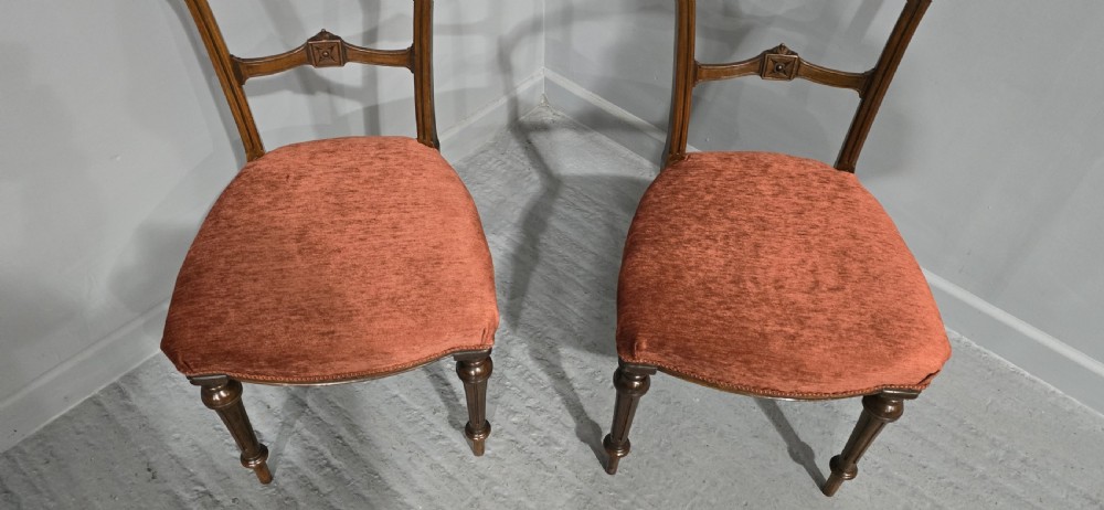 A pair of Victorian mahogany side chairs with openwork carved backs, turned front legs, and terracotta velvet seats. View III